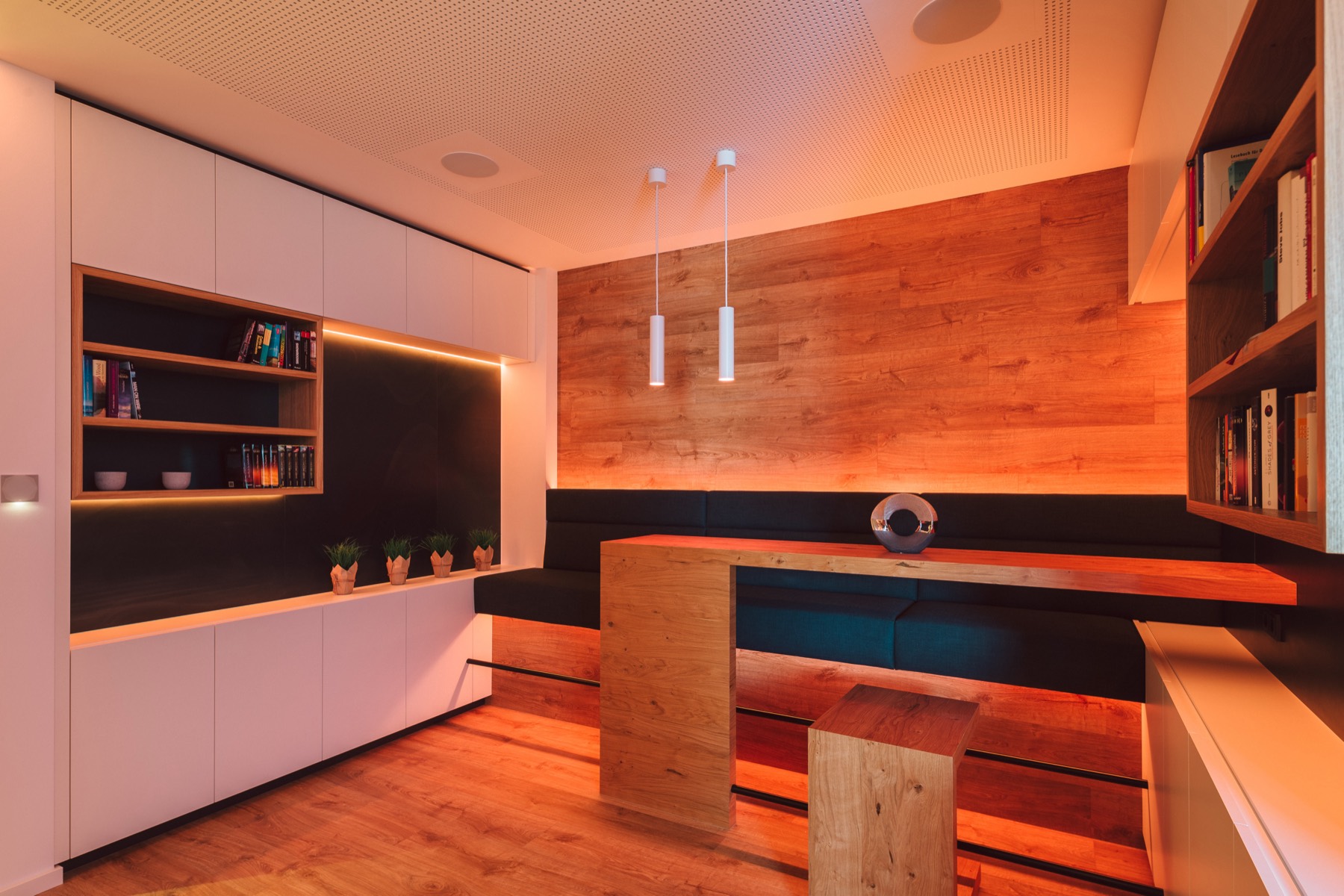 Lounge in the evening with warm accent lighting behind the shelves