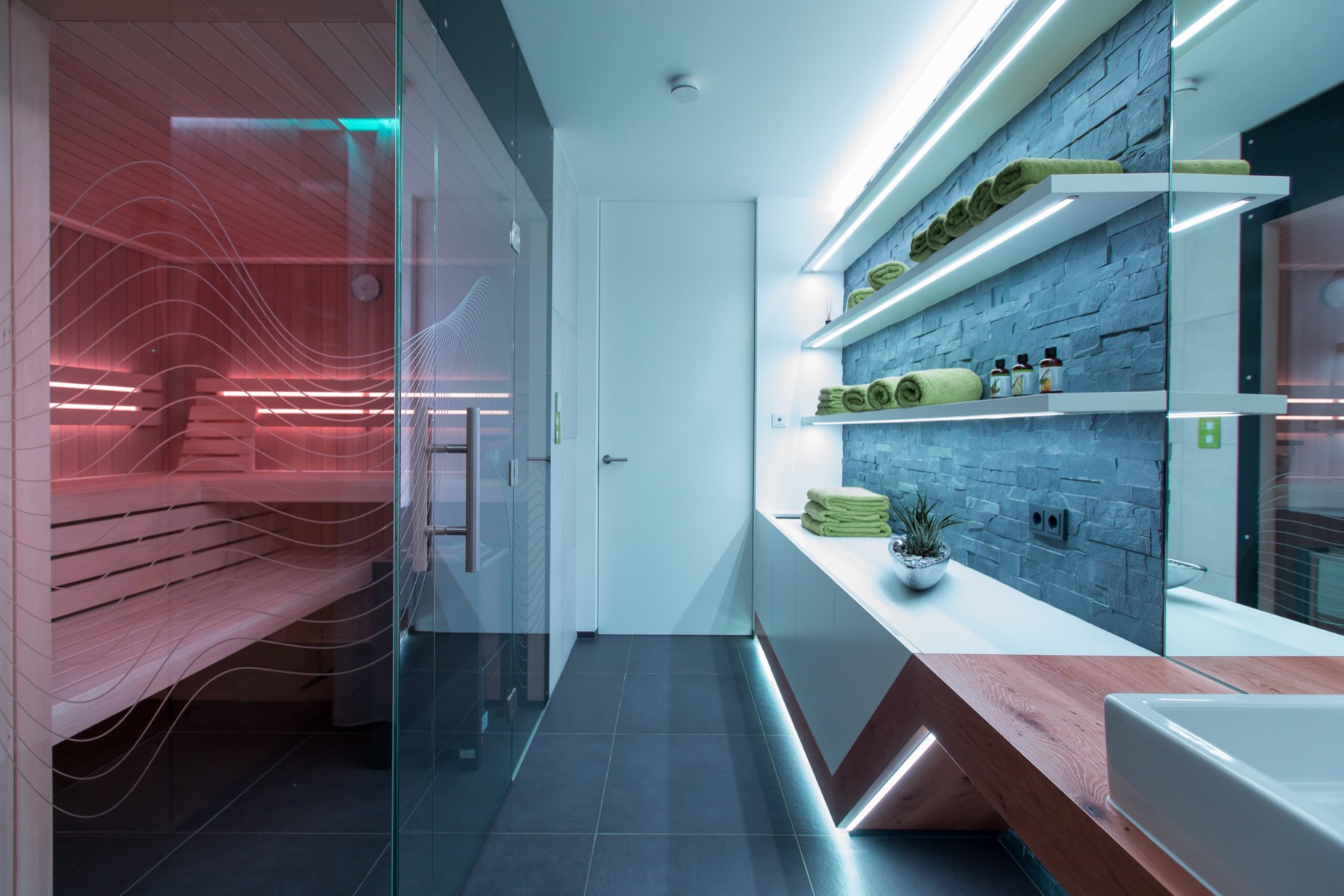 Home spa with sauna and stone wall lit by soft programmable light lines