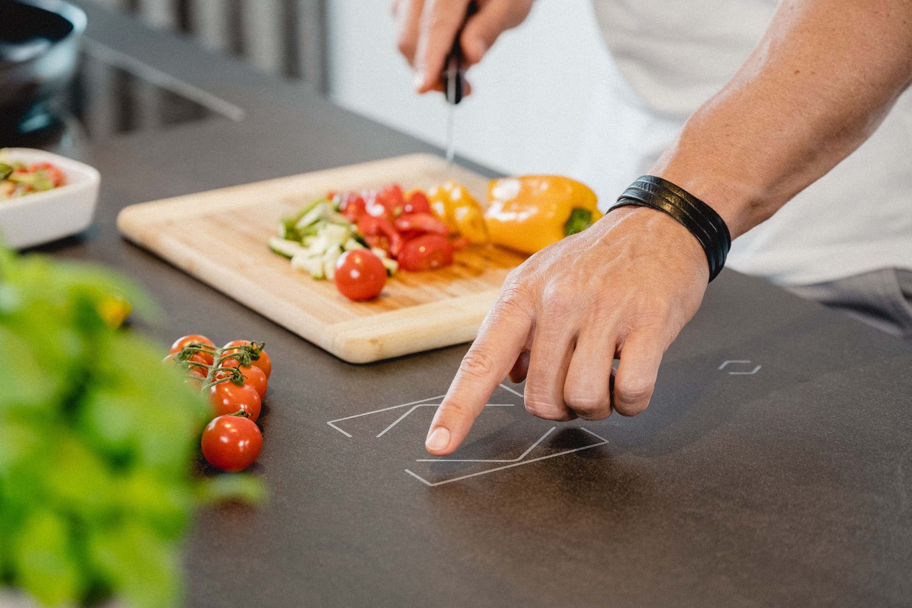 Hand using touch controls engraved directly into a kitchen countertop