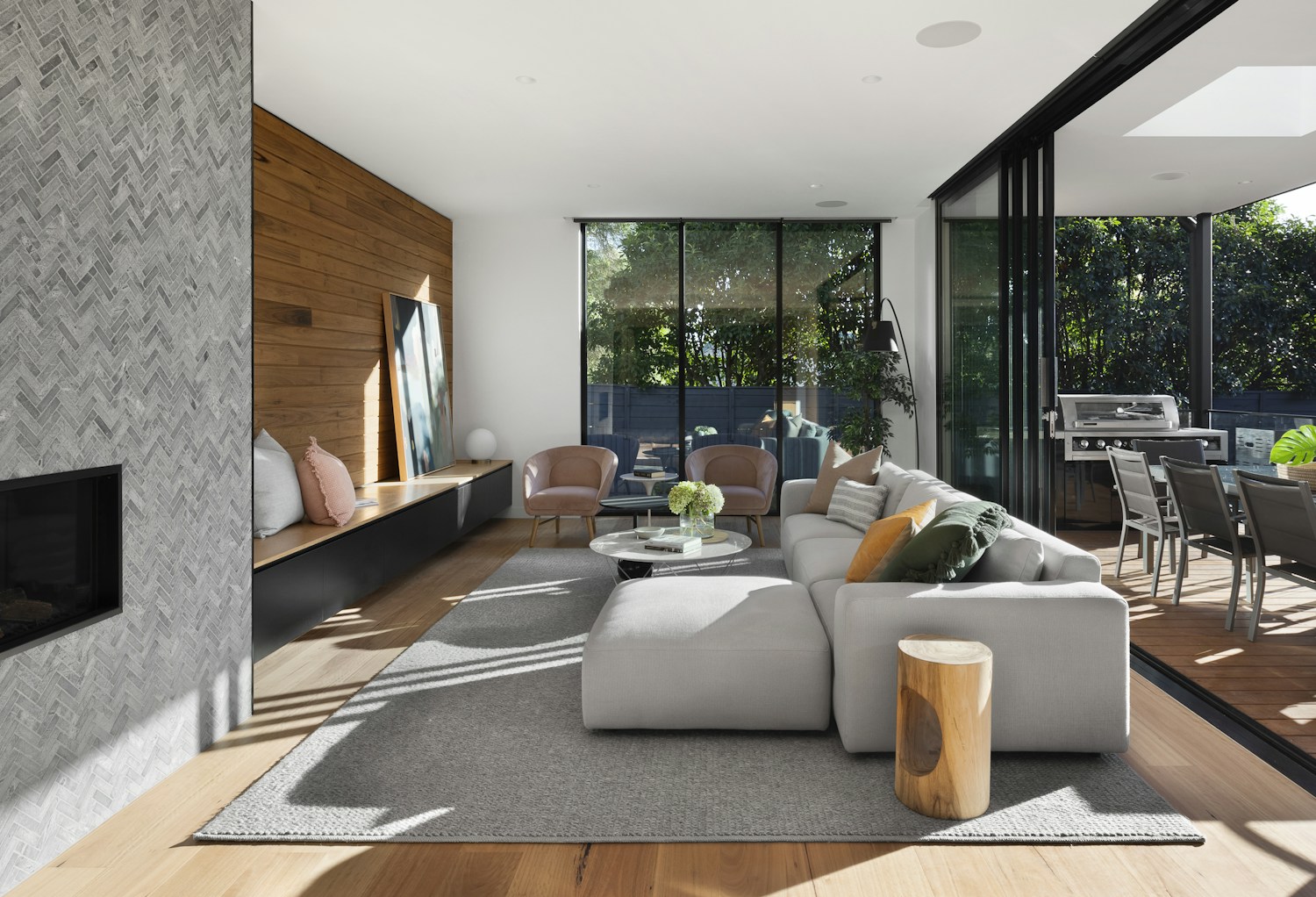 Warm, light-filled living room opening to an outdoor dining area